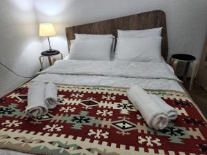 a bedroom with a bed with towels on it at Guest House Tbilisi style in Tbilisi City