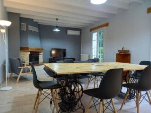 ベルジュラックにあるGîte d'Elvire Maison chaleureuse avec jacuzzi privatif et parc arboréの大きな木製テーブルと椅子が備わります。