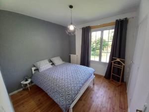 een slaapkamer met een bed en een raam bij Gîte d'Elvire Maison chaleureuse avec jacuzzi privatif et parc arboré in Bergerac