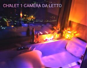 Atmosfera e vista mozzafiato Chalets في أَويستا: غرفة بها أريكة ونافذة في الليل