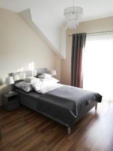 una camera con letto e lampadario a braccio di Apartament Olszynowy Gaj 4 a Cracovia