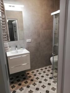 bagno con lavandino, servizi igienici e specchio di Apartament Olszynowy Gaj 4 a Cracovia