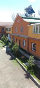 セヴァンにあるSevan Garden Complexの目の前に木々が生い茂るオレンジ色の建物