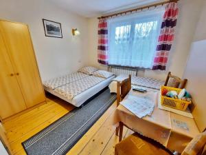 ザコパネにあるWynajem Pokoi Zakopaneのベッド2台とテーブルが備わる小さな客室です。