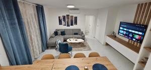 uma pequena sala de estar com um sofá e uma televisão em Superior Apartment Lisinski - Private parking - 2 & 3 Bedroom em Zagreb