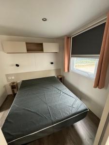 a small bedroom with a bed with a window at MH TIKE - 4p - Les Sables du Midi - Valras in Valras-Plage