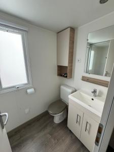 a white bathroom with a toilet and a sink at MH TIKE - 4p - Les Sables du Midi - Valras in Valras-Plage