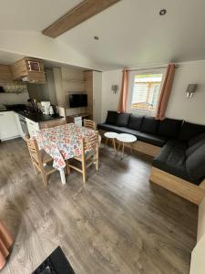 a living room with a table and a couch at MH TIKE - 4p - Les Sables du Midi - Valras in Valras-Plage