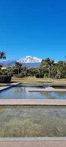 un bassin d'eau avec des montagnes en arrière-plan dans l'établissement Luxury Relaxing Home with heated pool near Catania, Taormina, the Sea and Mount Etna, à Giarre
