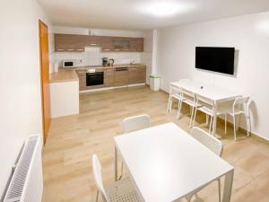 a kitchen and dining room with white tables and chairs at T&K Apartments - Wegberg - 3-6 Zimmer Apartments in Wegberg