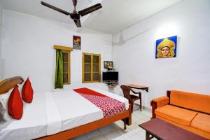 1 dormitorio con 1 cama y 1 sofá en Hotel Upasana, en Bhubaneshwar