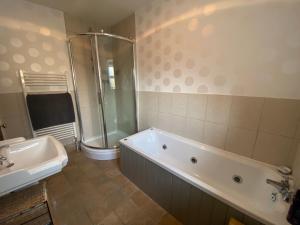 a bathroom with a tub and a shower and a sink at Alnwick Holiday House - Charming, Historic, Central Alnwick with Courtyard in Alnwick +35 photos