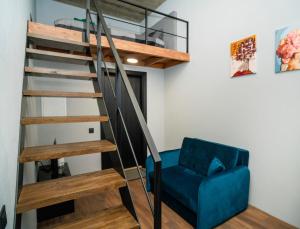 a living room with a spiral staircase and a blue chair at Teeny Tiny Lofts in Center in Kaunas +9 photos