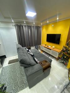 sala de estar con sofá y TV en Casa de Praia - Distância de 100 metros en Praia Grande