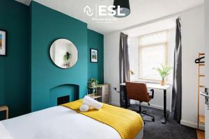 1 dormitorio con paredes verdes, 1 cama y escritorio en 3 bedroom House - Next to Wrexham FC Racecourse Stadium en Wrexham