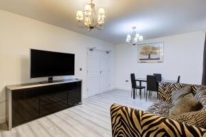 uma sala de estar com um sofá e uma televisão de ecrã plano em CrossVille Homes - 7 bed house, 3 baths, 3 parking em Navestock