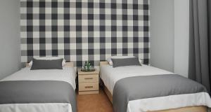 Hotel Klaudia في Juszczyn: سريرين يجلسون بجانب بعض في غرفة النوم