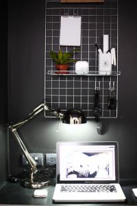 a laptop computer sitting on a desk with a lamp at Blu Monkey Hub and Hotel Phuket Town- Free All Day Coworking space in Phuket Town