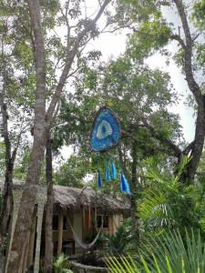 una cometa azul colgando de un árbol al lado de una casa en Casa Tzalam Tulum selva, en Tulum