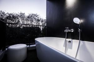a bathroom with a bath tub and a toilet at Blu Monkey Hub and Hotel Phuket Town- Free All Day Coworking space in Phuket Town
