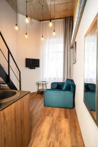 een woonkamer met een blauwe bank en een tafel bij Teeny Tiny Lofts in Center in Kaunas