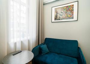 ein Wohnzimmer mit einem blauen Sofa und einem Tisch in der Unterkunft Teeny Tiny Lofts in Center in Kaunas