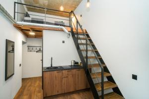 a kitchen with a staircase leading up to a loft at Teeny Tiny Lofts in Center in Kaunas