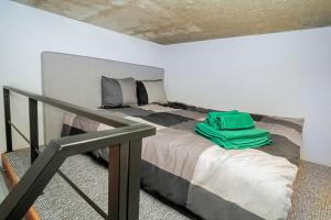 a bedroom with a bed with a green bag on it at Teeny Tiny Lofts in Center in Kaunas