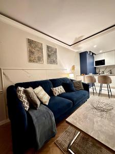 Una sala de estar con un sofá azul y una mesa. en Apartamenty Kielce- APARTAMENT SAPHIRE przy zalew kielecki, faktura, parking, centrum, en Kielce