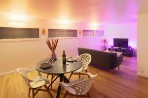 - un salon avec une table, des chaises et un canapé dans l'établissement Charmant appartement proche de Clermont-Ferrand, à Châteaugay