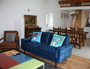 a living room with a blue couch and a table at gite des chênes in Phalsbourg