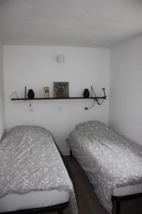 a room with two beds and a shelf on the wall at gite des chênes in Phalsbourg