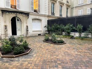 un patio con plantas de tres plantas frente a un edificio en Magnifique studio Champs-Elysée en París