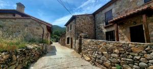 un callejón con edificios de piedra y una pared de piedra en Casa Rural El Castaño, en Navalguijo