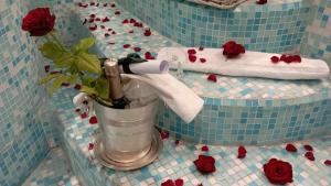 uma casa de banho com uma garrafa de champanhe e rosas em Eveline 2 - Piscina Privata o Jacuzzi em Sanremo