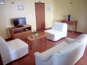 sala de estar con 2 sofás blancos y TV en Quinta Marvão en Ribamar