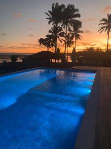 uma grande piscina com um pôr-do-sol ao fundo em Villa Garcez em Jaguaripe