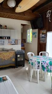 a room with a table and chairs and a bed at Casas Paz e Amor Praia do Rosa Sunset e Sunrise in Imbituba