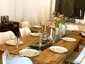 a wooden table with plates and wine bottles on it at Großes Waldhaus St Martin mit Sauna, Kamin & Natur in Sankt Martin