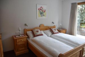 2 camas individuales en un dormitorio con ventana en FERIENWOHNUNGEN Chalet Hohturnen, en Grindelwald