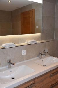 een badkamer met een witte wastafel en een spiegel bij FERIENWOHNUNGEN Chalet Hohturnen in Grindelwald