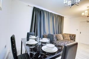 uma sala de estar com uma mesa e um sofá em CrossVille Homes - 7 bed house, 3 baths, 3 parking em Navestock
