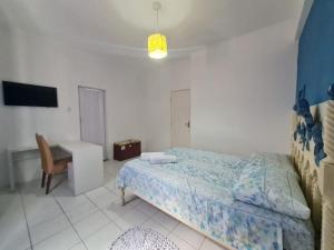 a bedroom with a bed and a desk and a chair at Pousada casa amarela in Salvador