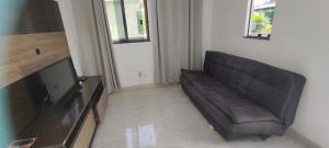 a living room with a couch and a flat screen tv at Casa Praia Dunas do Peró in Cabo Frio