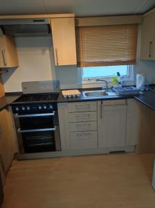 a kitchen with a stove and a sink at Dovercourt holiday park swift johnson low road harwich essex co12 3TZ in Parkeston +7 photos