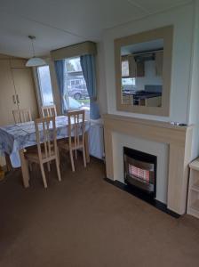 a dining room with a table and a fireplace at Swift johnson in Parkeston