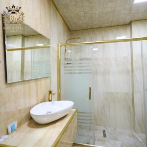 een badkamer met een wastafel en een douche bij Bey Hotel Baku in Baku