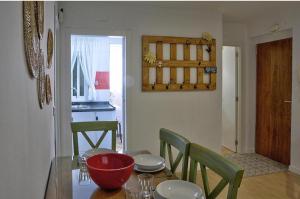 un comedor con una mesa con un tazón rojo. en Apartamento Triana en Sevilla