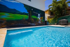 una piscina con un mural en el lateral de un edificio en Chris Guest House, en Rincón