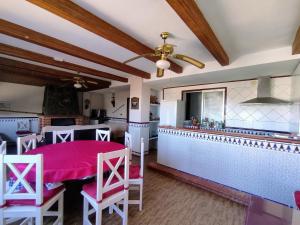 cocina y comedor con mesa y sillas rosas en A 15' Granada, Piscina, Habitaciones Familiares, Futbolín, Casa Medina Güevéjar, en Güevéjar